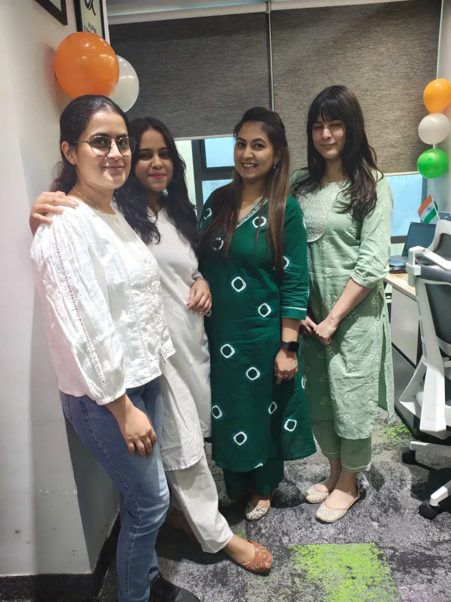 Four Alpha Consultants colleagues at a team celebration in the office